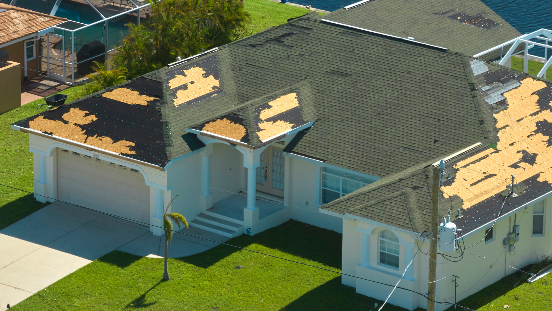 Storm-Damaged Roof | Higher Ground Roofing Home with storm-damaged roof missing shingles and underlayment exposed